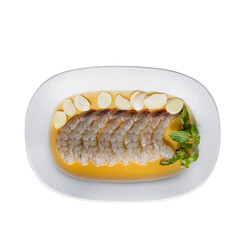 A plated dish featuring slices of fish in a flavorful broth, garnished with herbs and accompanied by citrus slices.