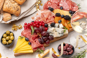 Party charcuterie board italian food antipasti prosciutto ham, salami and cheese appetizers served in the shape of a Christmas tree. party food for New Year's Eve, Christmas or birthday