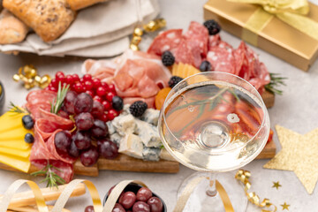 Glass of champagne, Prosecco or white  wine , festive aperitif or party food and drink with cold meat appetizers cheeses and olives , party food for New Year's Eve, Christmas or birthday
