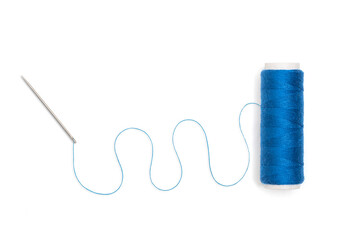 Blue spool of thread with needle isolated on white, top view