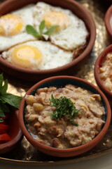 A bowl of creamy foul medames, a traditional Lebanese breakfast dish made with fava beans and chickpeas, garnished with fresh parsley, served in a rustic ceramic bowl.