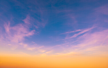 Sundown cloudscape. Fluffy clouds in the sunset of dark blue - pink - orange sky. Dreamy evening. Beautiful daybreak