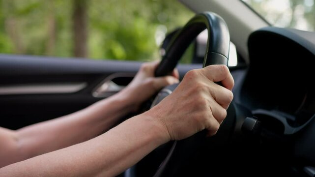 Close up unrecognizable elderly mature Caucasian senior woman aged auto driver car owner female wrinkled hands holding steering wheel buy new automobile dealership inside vehicle transport retirement
