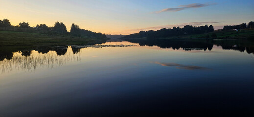 Beautiful Sunset Over Calm Lake with Tree Reflections and Tranquil Atmosphere
