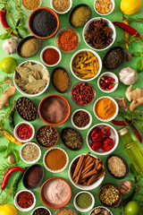 Brightly colored spices and herbs arranged on a delicate green background, highlighting their freshness and fragrance for a lively, natural look