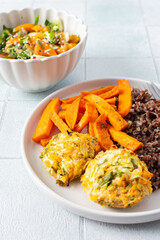 A healthy and filling meal of brown rice, baked sweet potato and squash chickpea pancakes, packed with flavor and nutrients, fresh salad of tomatoes and cucumbers