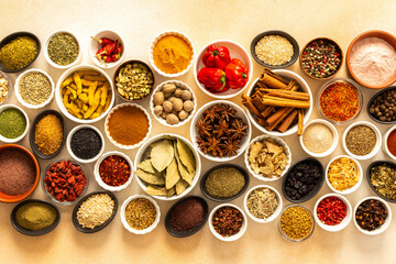 Diverse selection of cooking spices and dried herbs on a beige background, showcasing natural textures and colors that enhance culinary experiences