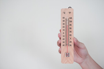 Hand holding classic room thermometer for checking temperature on white background isolation