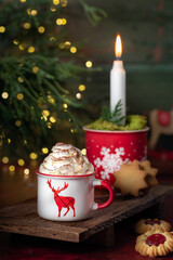 Gorąca czekolada z bitą śmietaną w świątecznym kubku. © Dorota