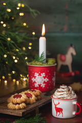 Gorąca czekolada z bitą śmietaną w świątecznym kubku. © Dorota