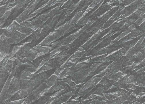 Сrumpled aluminum foil. Plastic transparent black cellophane background. Natural plastic texture surface.	