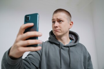 Serious Young Man Gray Hoodie Using Smartphone - Modern Digital Lifestyle