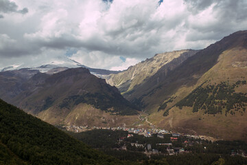 Fototapeta premium Gorgeous sky and rowing hills in the mountains with a small village countryside in the lowland, dark colours