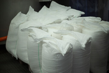 White bags. Bags of loose material. Construction material.