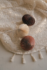 Christmas, New Year composition. Aesthetic Scandinavian Christmas paper honeycomb ornaments on crumpled draped elegant folds openwork lace cloth. Modern minimalist Christmas decoration. 