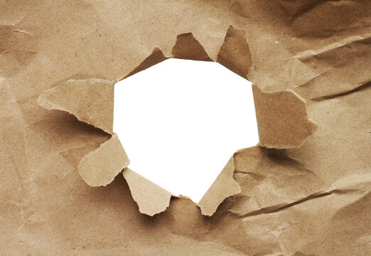 a torn sheet of brown paper with a hole in it revealing a transparent background