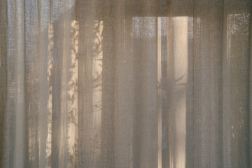 Floral sunlight shadows on a neutral beige linen curtains, aesthetic minimalist natural background...