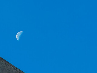 A large moon is visible in the sky above a blue sky