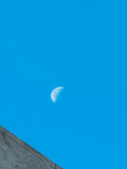 A large moon is in the sky above a blue sky