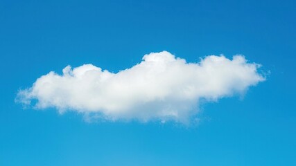 A white cloud forms against a bright blue backdrop with subtle texture and depth created by atmospheric effects, clouds, blurred background