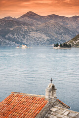 church belfry overlooking bay of Kotor Montenegro at sunset with Our Lady of the Rocks island