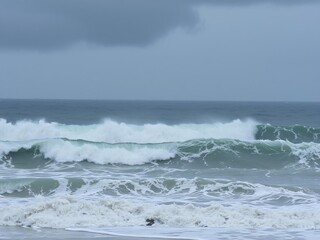 Fototapeta premium Stormy weather with massive waves pounding the shore, wave crash, pounding shore, rugged coastline