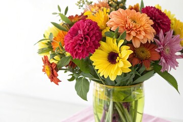 Vibrant mixed colors of dahlias sunflowers and alstroemeria in a brightly colored glass vase, bright colors, dahlia flowers, colorful fall wedding centerpieces
