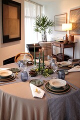 sophisticated table setting for dinner in a living room with candles in the center of the table