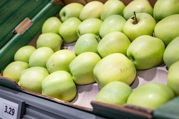 Green apples in a box in the store.