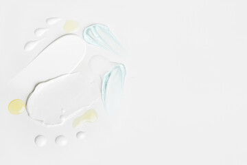 Beauty textures including cream smears, yellow drops, and blue gel details on a light surface with space for customization.