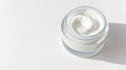 Glass bottle filled with a clear, moisturizing facial cream on a white surface, refined style, clean packaging