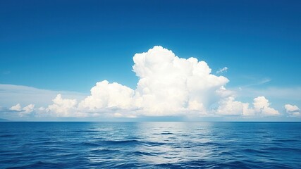 Fototapeta premium Serene blue sky with a large fluffy white cloud in the background, reflecting off the calm ocean waves below, peaceful landscape, tranquil atmosphere