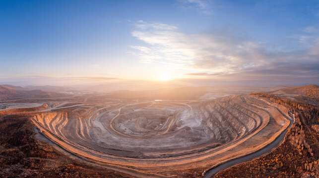 Panoramic of open pit mine industry, aerial view. Big yellow mining truck for coal working in quarry, sunrise