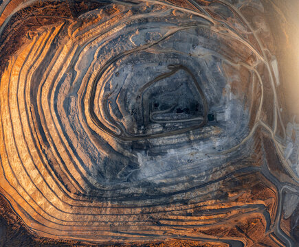 Open pit mine industry, aerial top view. Big yellow mining truck for coal working in quarry. Industrial landscape texture
