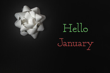 White bow is on a black background with the words Hello January
