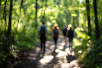 Fototapeta premium Blurred image of people walking in sunlit forest