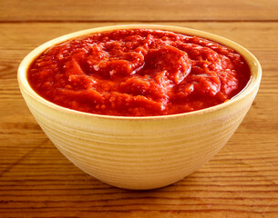 Tomaten Sauce in gelber Schale auf rustikalem hellem Holzfond, Tomatenpürree, 