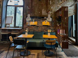 Interior dark design bakery shop coffee grocery. Industrial loft bar style. Seating area with bar tables and bar chairs in a modern cafe, industrial style with stone wall, wood and black steel