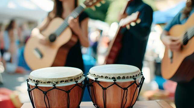 Up-close shot of musical instruments, such as bongos and guitars, with musicians in the background. 