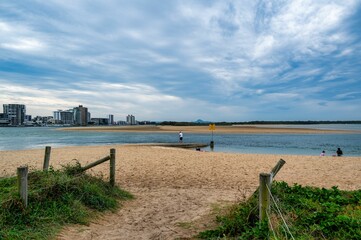 Sandy beach with city skyline in Caloundra, Australia.