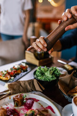 Man seasoning his salad in the restaurant.