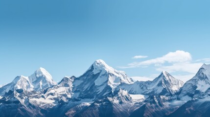 Towering snow-capped mountain peaks extend into a blue sky, epitomizing the grandeur and rugged beauty of alpine landscapes.