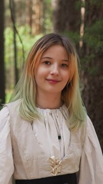 blonde girl smiles in medieval forest, close-up