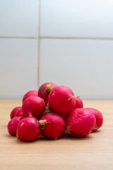 Fresh radishes on a kitchen counter, ready to be prepared for a healthy meal. Vibrant colors and natural textures highlight freshness and farm-to-table lifestyle. © Jmanita