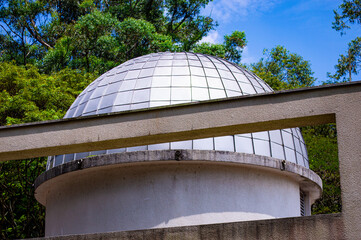 Obraz premium The Planetarium at Ibirapuera Park in São Paulo, Brazil. A modern architectural structure surrounded by greenery, with a clear sky and peaceful atmosphere, ideal for cultural tourism.
