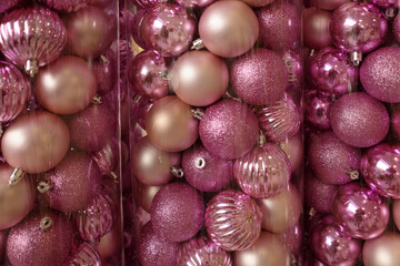 Plastic tubes with pink Christmas balls as Christmas background