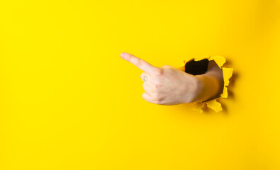 Hand pointing to the right on a yellow background