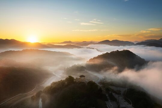 Breathtaking sunrise over a misty mountain landscape with rolling hills and a serene atmosphere