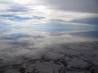 flooded salar de Uyuni in Bolivia in February with water surface mirroring the clouds in the sky in South America.