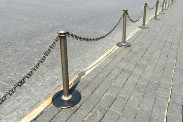 Border of old and modern stone tiles on Red Square in Moscow. Fence posts on pedestrian paths. Sidewalk